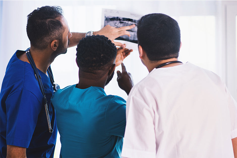 3 DIFC student dentists looking at an x-ray